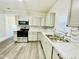 Renovated kitchen featuring modern appliances, white cabinets, and granite countertops at 602 Dexter St, Rocky Mount, NC 27803