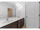 Double vanity bathroom with a large mirror, dark cabinets, neutral tile floors, and door to shower at 635 Grace Hodge Dr, Cary, NC 27519