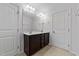 Double vanity bathroom features a large mirror, spacious dark cabinets, and neutral tile floors at 635 Grace Hodge Dr, Cary, NC 27519