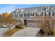 View of townhome with a spacious two-car garage, professional landscaping, and well-maintained grounds at 635 Grace Hodge Dr, Cary, NC 27519