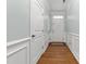 Bright hallway with wood floors, wainscoting, and white doors at 635 Grace Hodge Dr, Cary, NC 27519