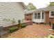 Brick patio with garden and potted plants leading to bay window and seating at 6517 Whitted Rd, Fuquay Varina, NC 27526