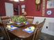 Cozy dining room with red wall covering, casual table setting and vintage decoration at 6517 Whitted Rd, Fuquay Varina, NC 27526