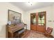 Inviting entryway featuring brick floors, a grand piano, and charming double glass doors at 6517 Whitted Rd, Fuquay Varina, NC 27526