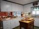 Efficient kitchen with white cabinets, an island with a wooden butcher block top, and lots of overhead and natural light at 6517 Whitted Rd, Fuquay Varina, NC 27526