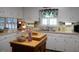 Functional kitchen with white cabinets, laminate countertops, a double stainless-steel sink, and a wooden island in the center at 6517 Whitted Rd, Fuquay Varina, NC 27526