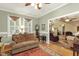 A cozy living room featuring hardwood floors, neutral walls, and an open doorway leading to additional living spaces at 6517 Whitted Rd, Fuquay Varina, NC 27526