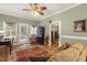 Comfortable living room featuring hardwood floors, a ceiling fan, access to a garden, and tasteful decorations and furnishings at 6517 Whitted Rd, Fuquay Varina, NC 27526