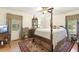 Bedroom with a four-poster bed, ceiling fan, and large windows offering natural light at 6517 Whitted Rd, Fuquay Varina, NC 27526
