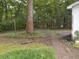 Trees surrounding the home with a brick path along the side yard at 6517 Whitted Rd, Fuquay Varina, NC 27526