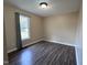 Cozy bedroom featuring wood-look floors, large window, and neutral paint at 803 Flat Rock Church Rd, Louisburg, NC 27549