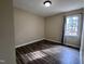 Another view of the bedroom, highlighting the wood-look floors and natural light from the window at 803 Flat Rock Church Rd, Louisburg, NC 27549