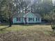 Charming single-story home with a light-green exterior and black shutters, surrounded by a spacious yard at 803 Flat Rock Church Rd, Louisburg, NC 27549