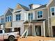 Modern townhomes under construction feature stylish exteriors, windows, and a truck with ladders nearby at 83 Ripple Way # 215, Clayton, NC 27520