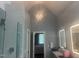 Bathroom with vanity, tiled walls, decorative lighting, and entrance to main bedroom at 8729 Valentine Ct, Raleigh, NC 27613