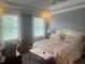 This bedroom features hardwood floors, two windows, and a bed with blankets at 8729 Valentine Ct, Raleigh, NC 27613