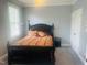 This bedroom features neutral walls, a bed with decorative pillows and blankets, and a window with blinds at 8729 Valentine Ct, Raleigh, NC 27613