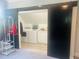 Laundry room with barn door, modern washer and dryer, and white cabinets at 8729 Valentine Ct, Raleigh, NC 27613