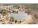 Aerial view of pond in community with mix of wooded areas and manicured lawns at 930 Pristine Ln, Rolesville, NC 27571