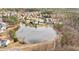An aerial view of a neighborhood pond and well manicured lawns at 930 Pristine Ln, Rolesville, NC 27571