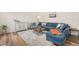 Comfortable living room features a blue sectional sofa, area rug, and wood floors at 930 Pristine Ln, Rolesville, NC 27571