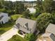 Beautiful aerial view of a home with well-manicured lawn, mature trees, and a view of a tranquil lake at 947 Middle Ground Ave, Rolesville, NC 27571