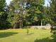 Well-maintained backyard featuring a lush green lawn, fence line, and manicured landscaping at 947 Middle Ground Ave, Rolesville, NC 27571