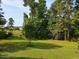 Picturesque backyard with mature trees, lush green lawn, and beautiful landscaping at 947 Middle Ground Ave, Rolesville, NC 27571
