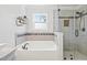 Bathroom featuring a bathtub, a separate glass shower, and decorative tile accents at 947 Middle Ground Ave, Rolesville, NC 27571