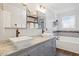 Bright bathroom with double sinks, marble countertops, modern fixtures, and a tub at 947 Middle Ground Ave, Rolesville, NC 27571