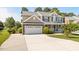 Two-story home with neutral siding, stone accents, attached garage, and a wide concrete driveway at 947 Middle Ground Ave, Rolesville, NC 27571