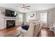 Cozy living room featuring a fireplace, ceiling fan, hardwood floors, and comfortable seating for relaxation at 947 Middle Ground Ave, Rolesville, NC 27571
