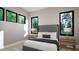 Serene bedroom featuring neutral tones, large windows, and minimalist decor for a calming retreat at 10 Gambel Dr, Youngsville, NC 27596