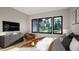 Comfortable bedroom with view of the outdoors, TV, accent chair, and plush bedding at 10 Gambel Dr, Youngsville, NC 27596