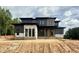Modern home featuring a sleek design, dark siding, large windows, and a contemporary architectural style at 10 Gambel Dr, Youngsville, NC 27596