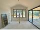 Bright living room with large windows and sliding doors, with construction materials on the floor at 10 Gambel Dr, Youngsville, NC 27596