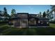 Modern dark home features a covered outdoor living space and ample backyard greenery at 10 Gambel Dr, Youngsville, NC 27596