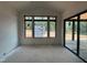 Well-lit room with large windows and sliding glass door, offering a view of the landscape, showcasing a modern design at 10 Gambel Dr, Youngsville, NC 27596
