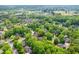 An aerial view shows this single-Gathering home nestled among mature trees and lush landscaping in a quiet neighborhood at 102 Pin Oak Ct, Elon, NC 27244