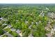 An aerial perspective of a home surrounded by beautiful green trees in a suburban neighborhood at 102 Pin Oak Ct, Elon, NC 27244
