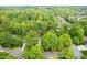Aerial view of a home nestled amongst mature trees in a suburban neighborhood at 102 Pin Oak Ct, Elon, NC 27244