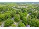 An aerial view of the home nestled in a lush, green, tree-filled community with mature landscaping at 102 Pin Oak Ct, Elon, NC 27244