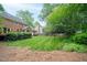 Lush, green backyard featuring a manicured lawn and mature trees at 102 Pin Oak Ct, Elon, NC 27244