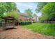 Spacious backyard featuring a well-maintained lawn, brick home, deck, and gazebo at 102 Pin Oak Ct, Elon, NC 27244
