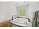 Soaking tub situated under a bright window at 102 Pin Oak Ct, Elon, NC 27244