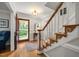 Inviting foyer with hardwood floors, elegant staircase, and an open view to the outdoors at 102 Pin Oak Ct, Elon, NC 27244