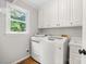 Convenient laundry room featuring modern washer and dryer units, storage, and lots of natural light at 102 Pin Oak Ct, Elon, NC 27244