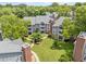 Lovely aerial view of condominiums and walkways with mature trees, and lush green grass at 1061 Wirewood Dr # 303, Raleigh, NC 27605