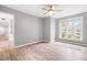 Spacious bedroom featuring a large window with neighborhood views, light walls, a ceiling fan, and hardwood flooring at 1061 Wirewood Dr # 303, Raleigh, NC 27605