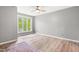 Light-filled bedroom with neutral walls, ceiling fan, and natural wood flooring, creating a comfortable and inviting space at 1061 Wirewood Dr # 303, Raleigh, NC 27605